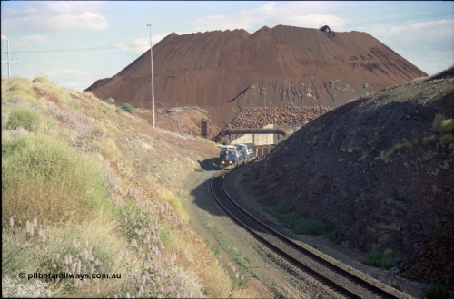 221-29
Yandi One mine loadout balloon loop, a pair of General Electric AC6000 units lead a train being loaded around the balloon, overview of the stockpile with stacker fill the hole from loading.
Keywords: GE;AC6000;51062-9;