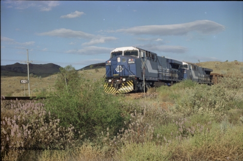 221-30
Yandi One mine loadout balloon loop, near new General Electric AC6000 unit 6074 serial 51066 leads sister unit 6071 serial 51063 at the Y312.1 km crossing while controlling a train being loaded.
Keywords: 6074;GE;AC6000CW;51066;