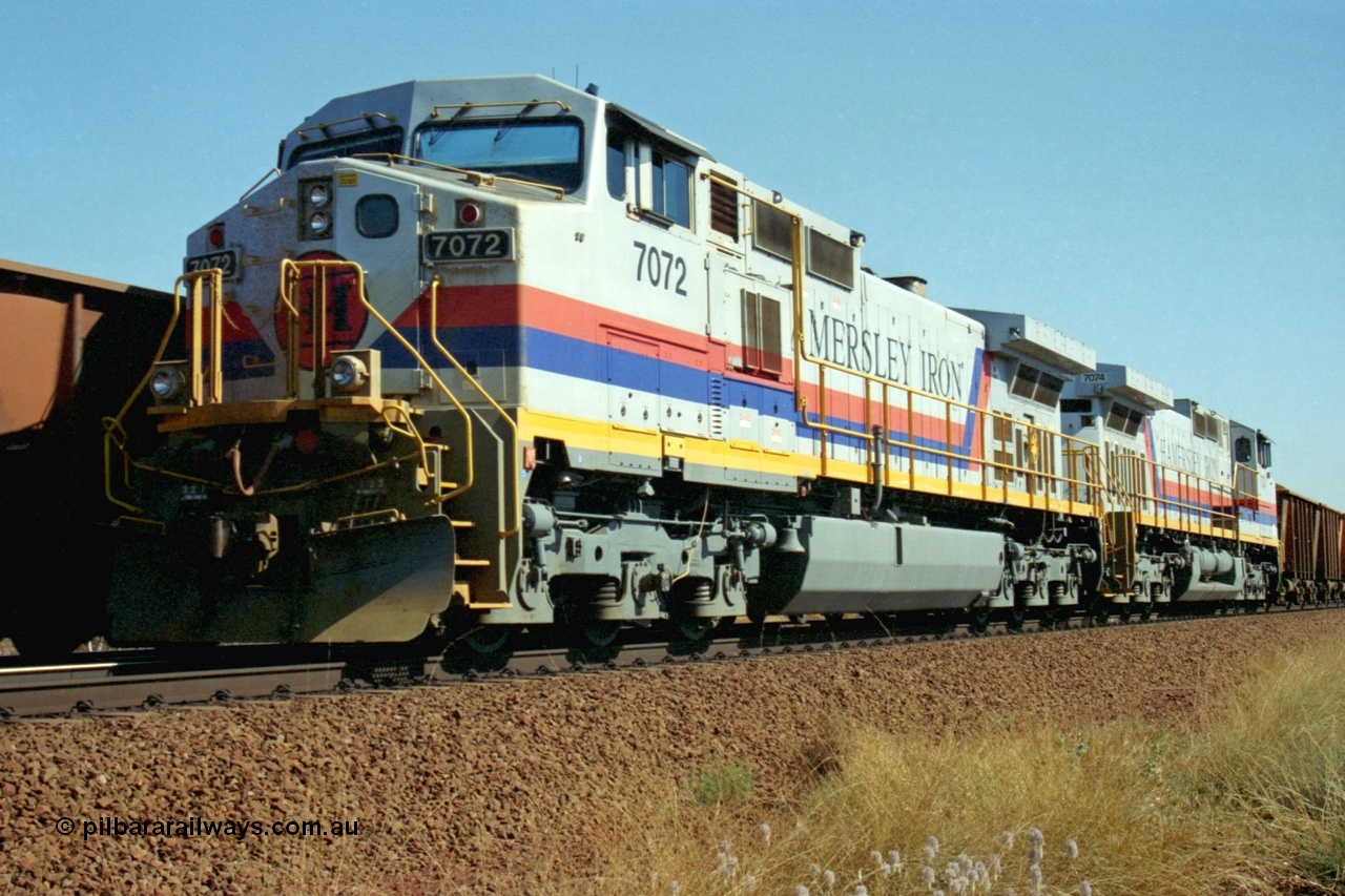 223-32
Possum Siding, a loaded train behind a pair of Hamersley Iron General Electric built Dash 9-44CW units 7072 serial 47751 and 7074 serial 47753 with the crew change completed, the empty is rolling past on the passing track. 21st October 2000.
Keywords: 7072;47751;GE;Dash-9-44CW;