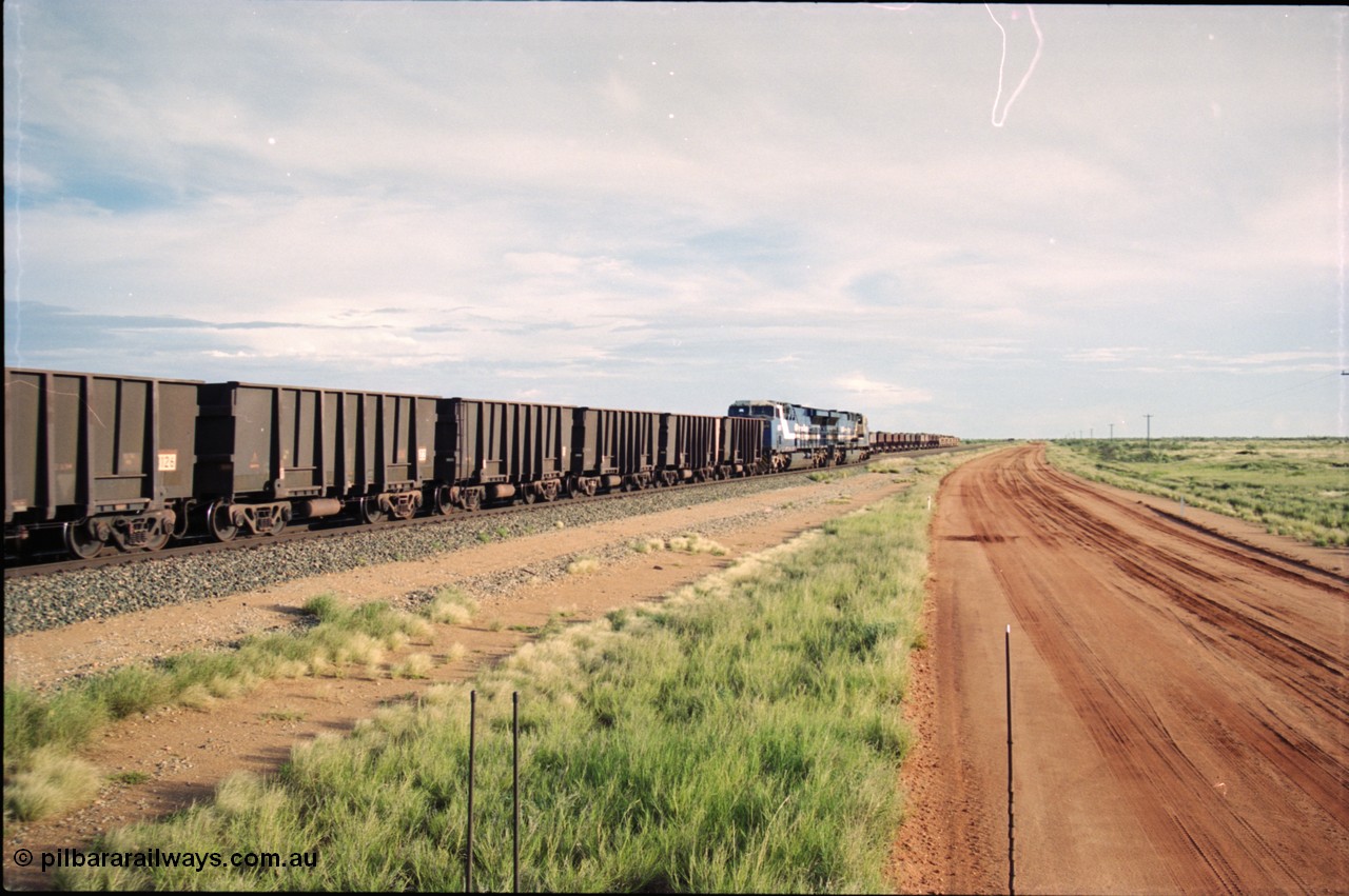 225-07
Bing siding, the afternoon departure for Yandi mine heads south past the ballast consist, behind the standard double General Electric AC6000 units with GE Erie built 6075 serial 51067 second unit to lead sister unit 6074 with another AC6000 unit mid-train. This was before the units were named. [url=https://goo.gl/maps/r3bVfZz8aJS2]GeoData[/url].
