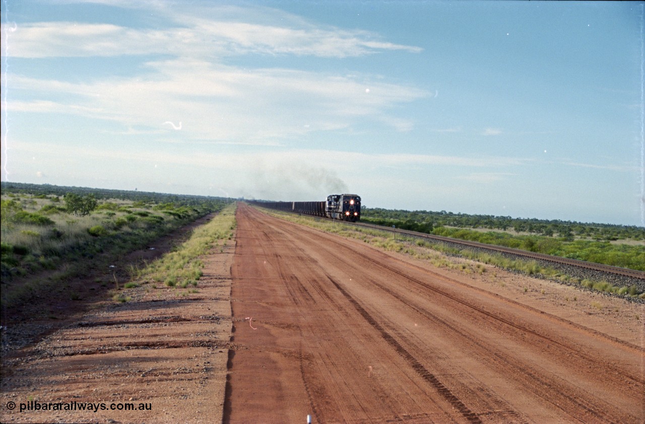 225-15
At the 24.1 km grade crossing on the BHP Newman line, the afternoon departure for Yandi mine heads south behind the standard double General Electric AC6000 units with another AC6000 unit mid-train. [url=https://goo.gl/maps/qGkyfiuy6212]GeoData[/url].
