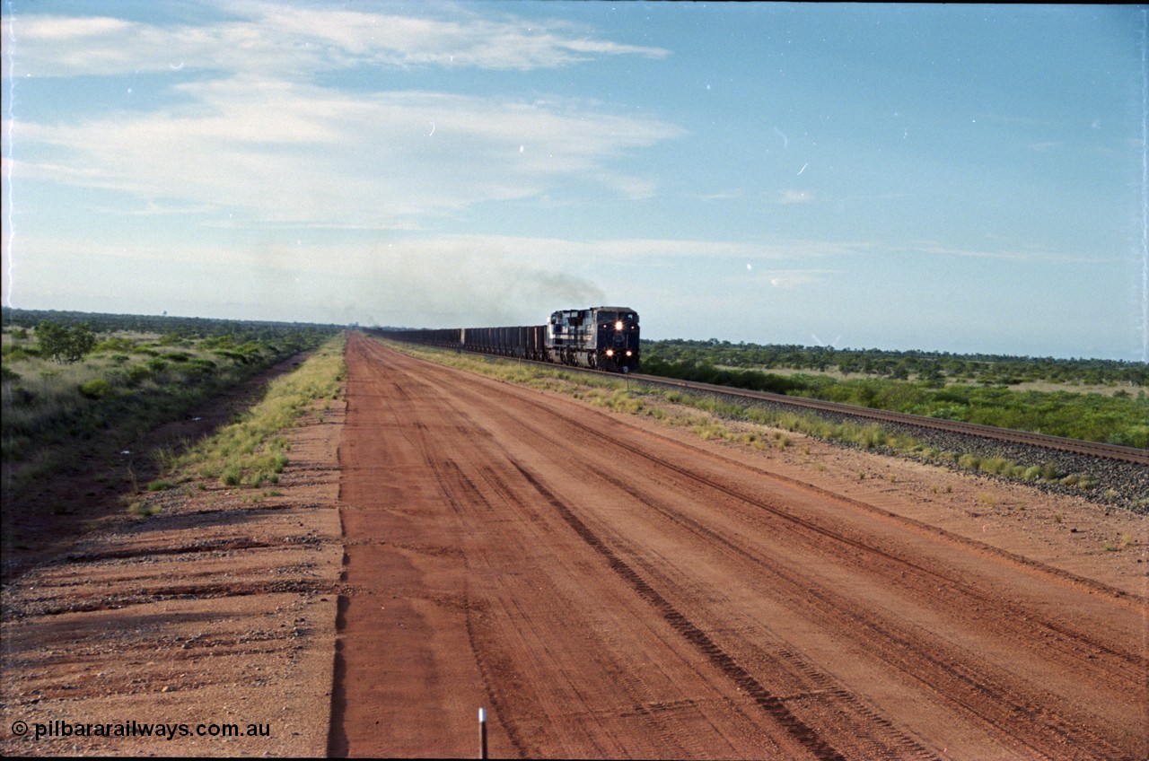 225-16
At the 24.1 km grade crossing on the BHP Newman line, the afternoon departure for Yandi mine heads south behind the standard double General Electric AC6000 units with another AC6000 unit mid-train. [url=https://goo.gl/maps/qGkyfiuy6212]GeoData[/url].
