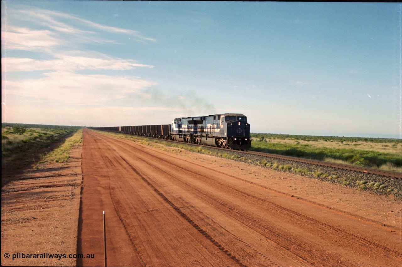225-18
At the 24.1 km grade crossing on the BHP Newman line, the afternoon departure for Yandi mine heads south behind the standard double General Electric AC6000 units with GE Erie built 6074 serial 51066 leading sister unit 6075 with another AC6000 unit mid-train. This was before the units were named. [url=https://goo.gl/maps/qGkyfiuy6212]GeoData[/url].
Keywords: 6074;GE;AC6000;51066;