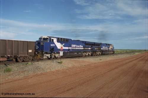 225-21
At the 24.1 km grade crossing on the BHP Newman line, the afternoon departure for Yandi mine heads south behind the standard double General Electric AC6000 units with GE Erie built 6075 serial 51067 second unit to lead sister unit 6074 with another AC6000 unit mid-train. This was before the units were named. [url=https://goo.gl/maps/qGkyfiuy6212]GeoData[/url].
Keywords: 6075;GE;AC6000CW;51067;