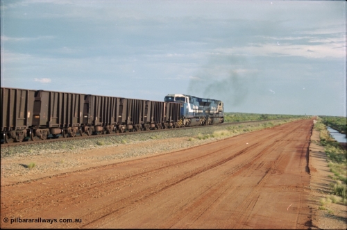 225-22
At the 24.1 km grade crossing on the BHP Newman line, the afternoon departure for Yandi mine heads south behind the standard double General Electric AC6000 units with GE Erie built 6075 serial 51067 second unit to lead sister unit 6074 with another AC6000 unit mid-train. This was before the units were named. [url=https://goo.gl/maps/qGkyfiuy6212]GeoData[/url].
