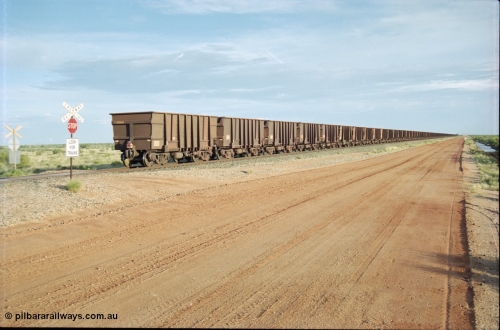 225-25
At the 24.1 km grade crossing on the BHP Newman line the end of the afternoon Yandi train is seen heading south with last waggon 4305, one of 126 such waggons constructed during 1997 out of 3CR12 stainless steel in an effort to eliminate painting and to reduce wear on the waggon body. This design was designated HC7081. [url=https://goo.gl/maps/qGkyfiuy6212]GeoData[/url].
Keywords: 4305;United-Goninan-WA;3CR12;HC7081;