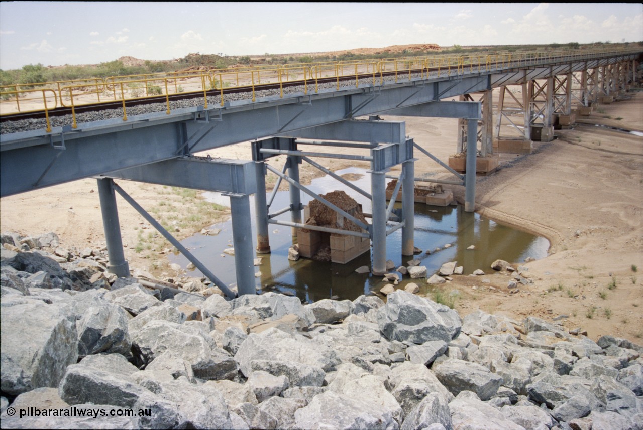 226-04
Yule River bridge showing new piles and deck to replace flood damaged piles after a cyclone that closed the line for two weeks in the late 1990s. [url=https://goo.gl/maps/G67Mat23u4P2]GeoData[/url].
