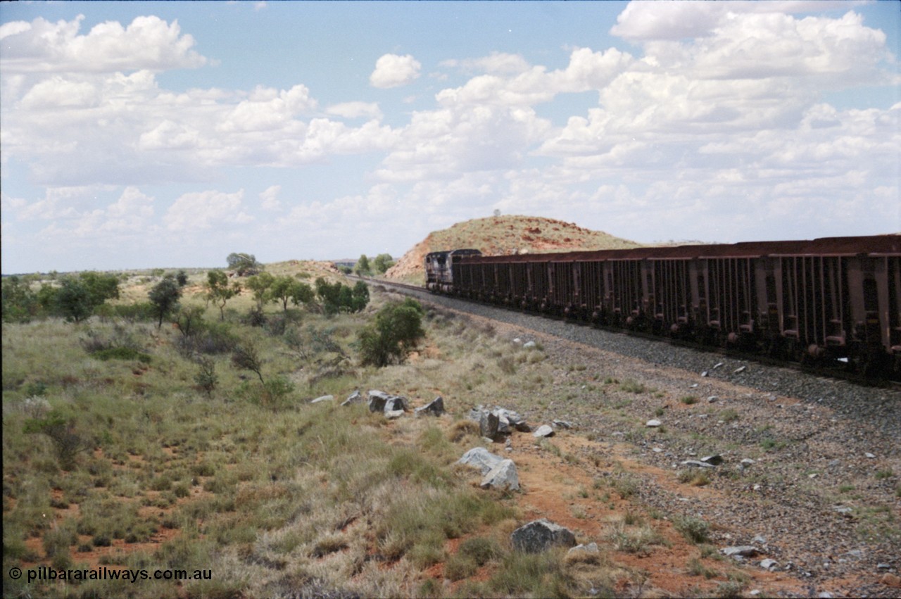 226-08
Redmont, 202 km with a loaded Yandi train speeding north towards the port behind a pair of CM40-8M locomotives with the distinctive flat top loading profile of the Yandi loadouts. [url=https://goo.gl/maps/HYx9nXwpXfP2]GeoData[/url].
