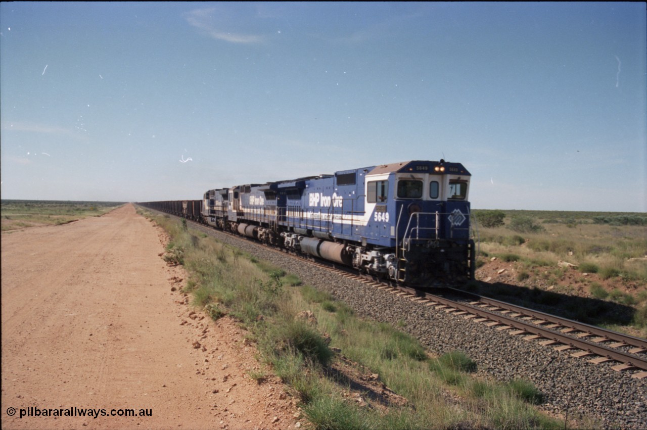 227-23
30 km area on the Newman mainline, east of the original Quarry 1, an empty train powers along the gentle .17% rising grade behind Goninan CM40-8M GE rebuilds 5649 'Pohang' serial 8412-07/93-140 and 5651 with third unit an General Electric AC6000. [url=https://goo.gl/maps/BY7Zz4F5t822]GeoData[/url].
Keywords: 5649;Goninan;GE;CM40-8M;8412-07/93-140;rebuild;AE-Goodwin;ALCo;M636C;5473;G6047-5;