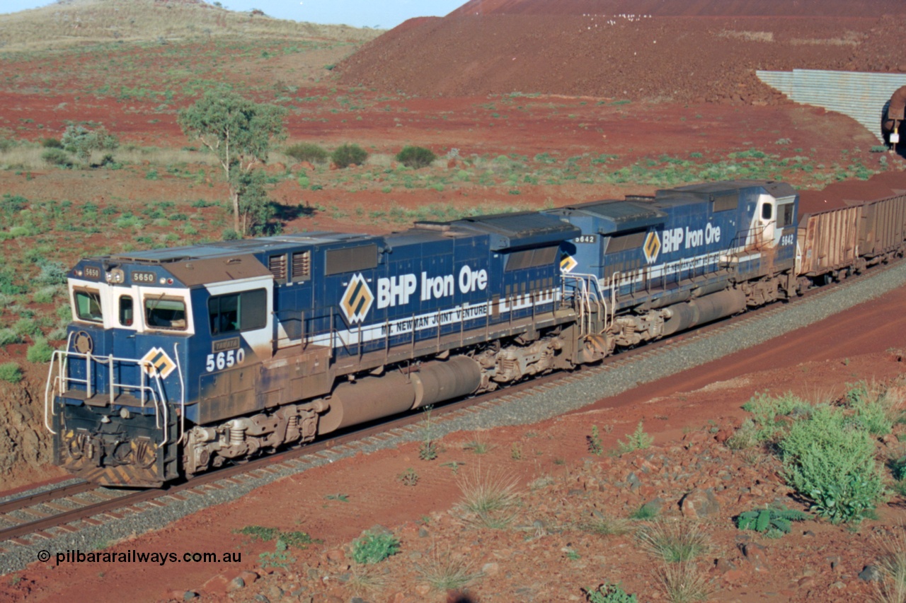 229-29
Yandi Two loadout exit side, Goninan rebuild CM40-8M GE units 5650 'Yawata' serial 8412-07 / 93-141 and sister unit 5642 drag a loading train at 1.2 km/h, both units carry the BHP Iron Ore teal and marigold livery for the logo. [url=https://goo.gl/maps/KQ3dQNrTwd42]GeoData[/url].
Keywords: 5650;Goninan;GE;CM40-8M;8412-07/93-141;rebuild;AE-Goodwin;ALCo;M636C;5481;G6061-2;