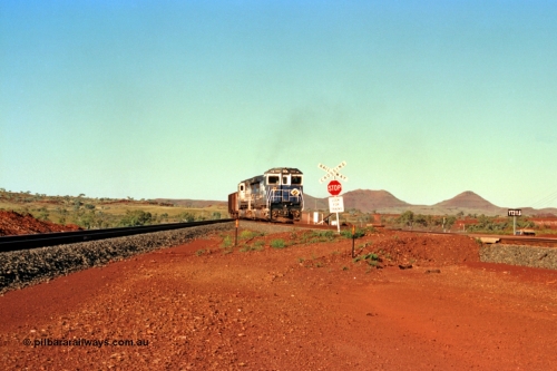 229-02
Yandi Two balloon switch looking east with the Three Sisters forming the background. Empty BHP train heading for the balloon loop for loading, grade crossing is the YT 311.5 km. [url=https://goo.gl/maps/DcycDGojcBt]GeoData[/url].
