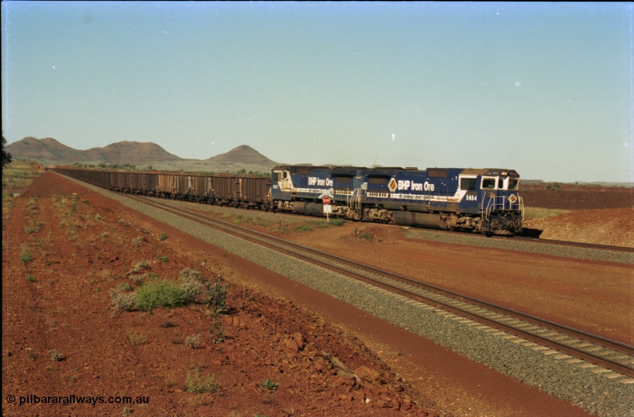 230-08
Yandi Two switch looking east with the Three Sisters forming the background. Empty BHP train behind CM40-8M units 5654 and 5637 crossing the YT 311.5 km grade crossing. Geodata [url=https://goo.gl/maps/DcycDGojcBt] -22.713725, 119.055762 [/url].
