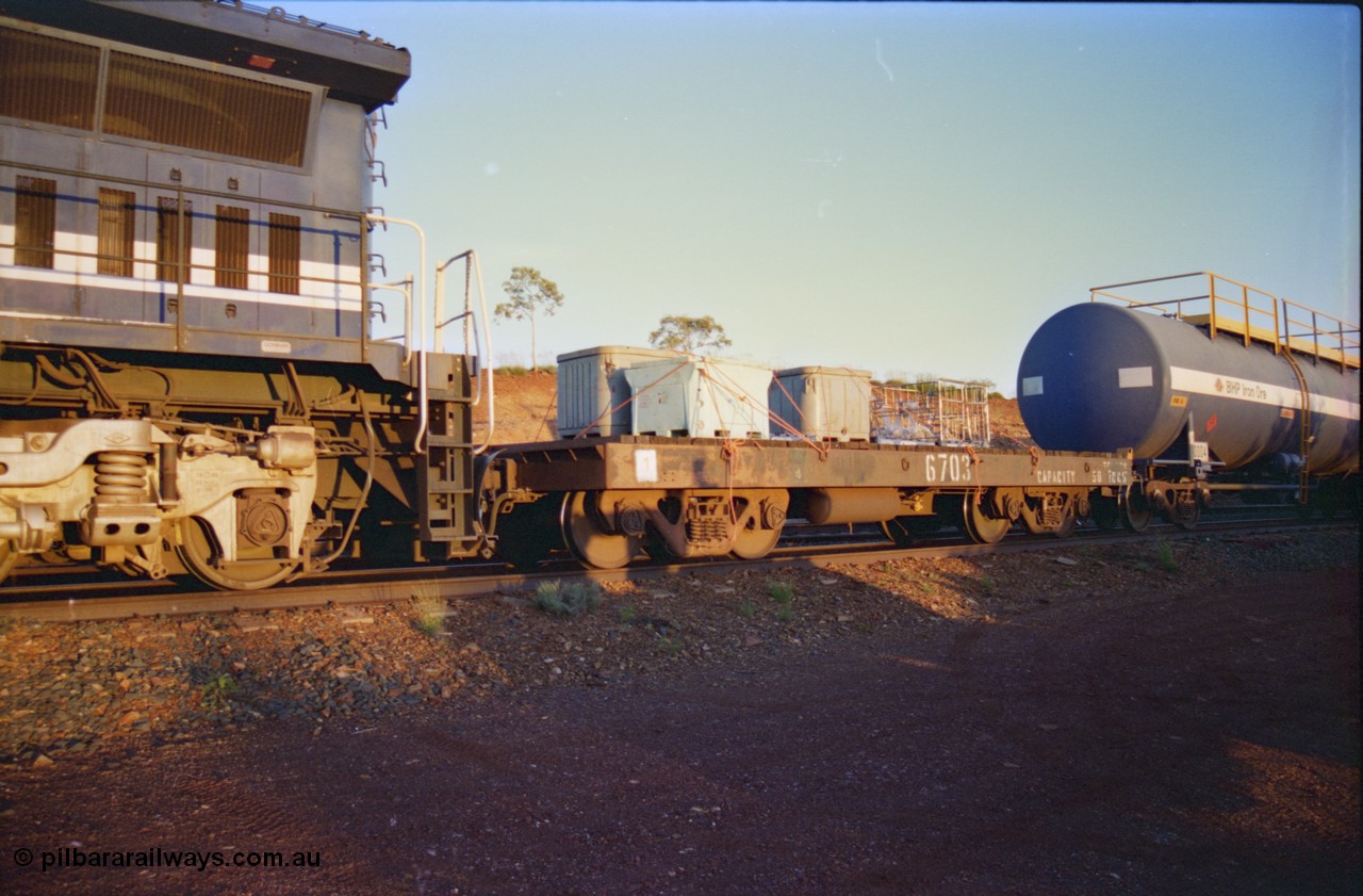 232-13
Yandi One backtrack, following a cyclone shutdown of the mainline and severe flooding around Yandi a 'mixed' freight train was operated to Yandi to deliver food, mail and diesel fuel to the mine and camp. Here BHP Iron Ore 50 ton waggon 6703, one of three 'special' waggons converted from Magor USA built ore waggons by the Mt Newman Workshops. [url=https://goo.gl/maps/6c1WFqjYSg42]GeoData[/url].
Keywords: 6703;Mt-Newman-Mining-WS;Magor-USA;