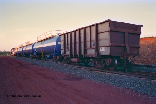 232-19
Yandi One backtrack, following a cyclone shutdown of the mainline and severe flooding around Yandi a 'mixed' freight train was operated to Yandi to deliver food, mail and diesel fuel to the mine and camp. Here BHP Iron Ore loaded Comeng WA built ore waggon 2871 has been re-sheeted with 3CR12 stainless steel side walls. February 1997. [url=https://goo.gl/maps/6c1WFqjYSg42]GeoData[/url].
Keywords: 2871;Comeng-WA;BHP-ore-waggon;