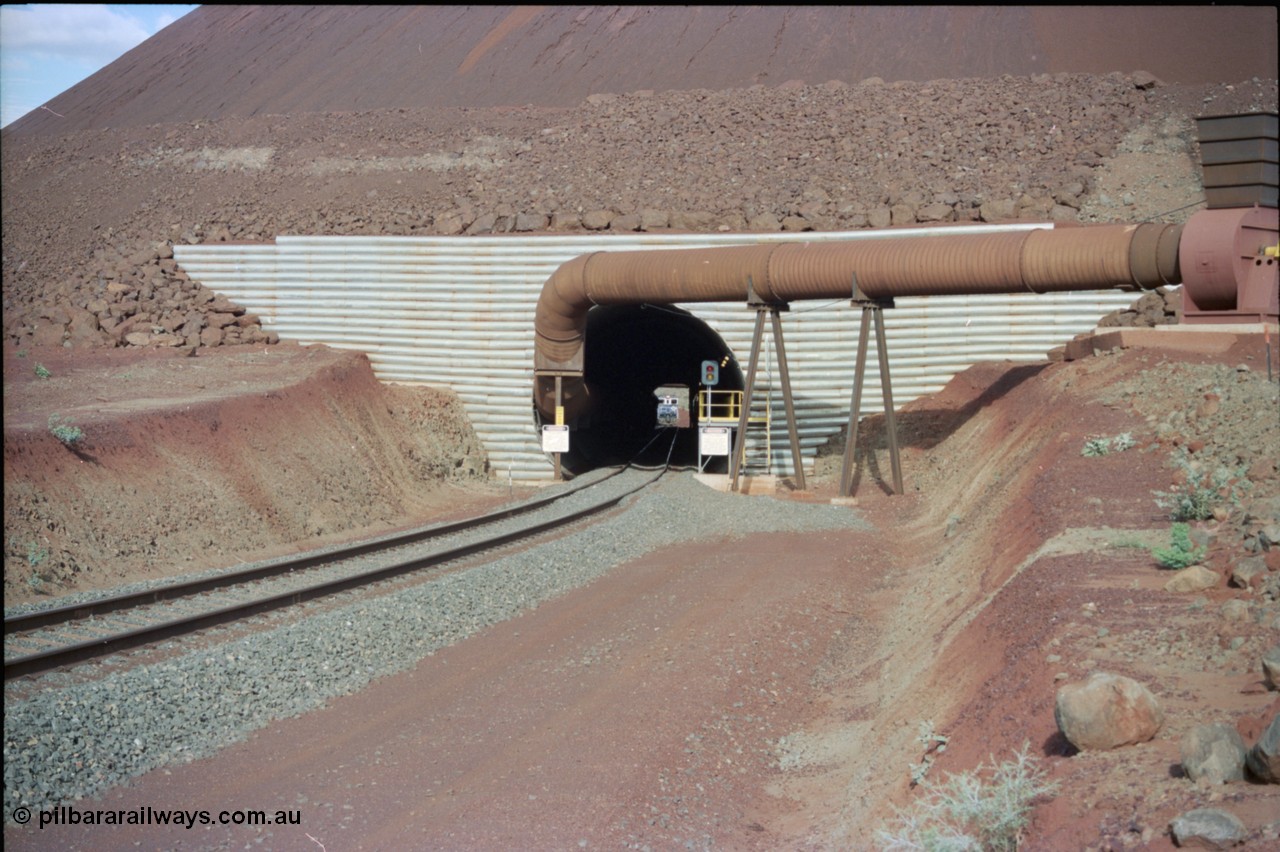233-02
Yandi Two exit portal or loaded car side of load-out tunnel, the Yandi Two load-out has two load-out stations or vaults to allow to different products to be loaded. Only one vault is used at a time. An empty train can be seen about to enter the tunnel. [url=https://goo.gl/maps/RgJfYGtPXb52]GeoData[/url].
