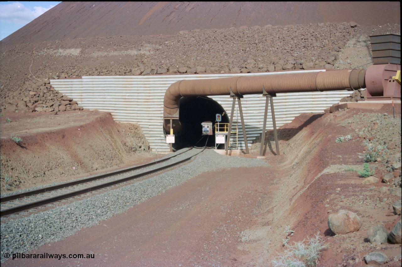 233-03
Yandi Two exit portal or loaded car side of load-out tunnel, the Yandi Two load-out has two load-out stations or vaults to allow to different products to be loaded. Only one vault is used at a time. An empty train can be seen about to enter the tunnel. [url=https://goo.gl/maps/RgJfYGtPXb52]GeoData[/url].

