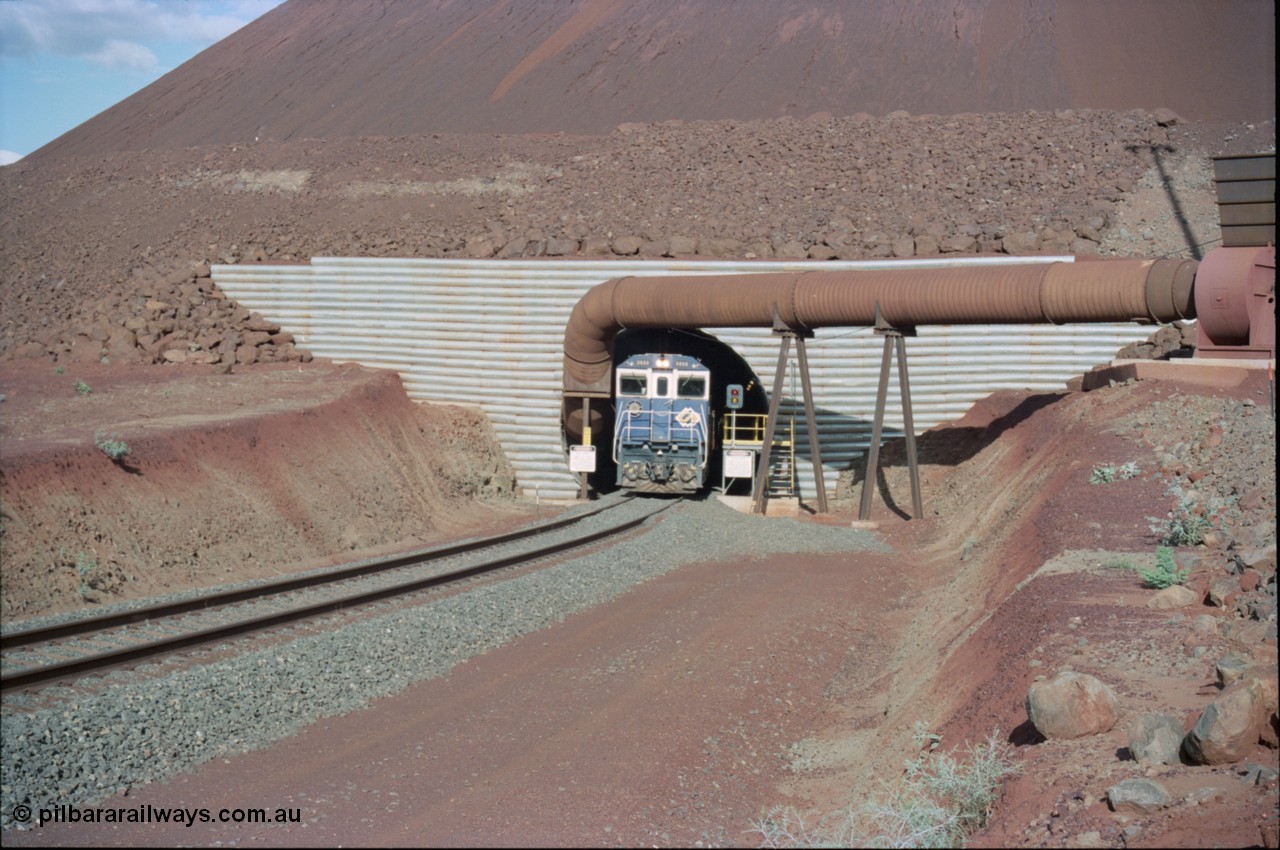 233-09
Yandi Two exit portal or loaded car side of load-out tunnel, the Yandi Two load-out has two load-out stations or vaults to allow to different products to be loaded. Only one vault is used at a time. A loading train lead by BHP Iron Ore's Goninan rebuild CM40-8M GE unit 5650 'Yawata' serial 8412-07 / 93-141 as it drags the train through at 1.2 km/h. [url=https://goo.gl/maps/RgJfYGtPXb52]GeoData[/url].
Keywords: 5650;Goninan;GE;CM40-8M;8412-07/93-141;rebuild;AE-Goodwin;ALCo;M636C;5481;G6061-2;
