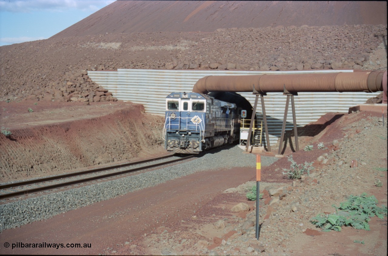 233-12
Yandi Two exit portal or loaded car side of load-out tunnel, the Yandi Two load-out has two load-out stations or vaults to allow to different products to be loaded. Only one vault is used at a time. A loading train lead by BHP Iron Ore's Goninan rebuild CM40-8M GE unit 5650 'Yawata' serial 8412-07 / 93-141 as it drags the train through at 1.2 km/h. [url=https://goo.gl/maps/RgJfYGtPXb52]GeoData[/url].
Keywords: 5650;Goninan;GE;CM40-8M;8412-07/93-141;rebuild;AE-Goodwin;ALCo;M636C;5481;G6061-2;