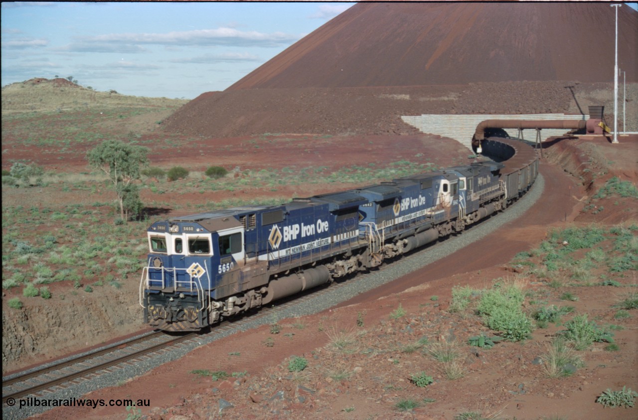 233-27
Yandi Two loaded car side of load-out tunnel, a loading train lead by BHP Iron Ore's Goninan rebuild CM40-8M GE unit 5650 'Yawata' serial 8412-07 / 93-141 as it drags the train through at 1.2 km/h with assistance from two sister units. [url=https://goo.gl/maps/gXRbfYH9U482]GeoData[/url].
Keywords: 5650;Goninan;GE;CM40-8M;8412-07/93-141;rebuild;AE-Goodwin;ALCo;M636C;5481;G6061-2;