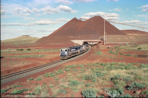 233-22
Yandi Two exit portal or loaded car side of load-out tunnel, the Yandi Two load-out has two load-out stations or vaults to allow to different products to be loaded. Only one vault is used at a time. A loading train lead by BHP Iron Ore's Goninan rebuild CM40-8M GE unit 5650 'Yawata' serial 8412-07 / 93-141 as it drags the train through at 1.2 km/h with assistance from two sister units. [url=https://goo.gl/maps/gXRbfYH9U482]GeoData[/url].
Keywords: 5650;Goninan;GE;CM40-8M;8412-07/93-141;rebuild;AE-Goodwin;ALCo;M636C;5481;G6061-2;