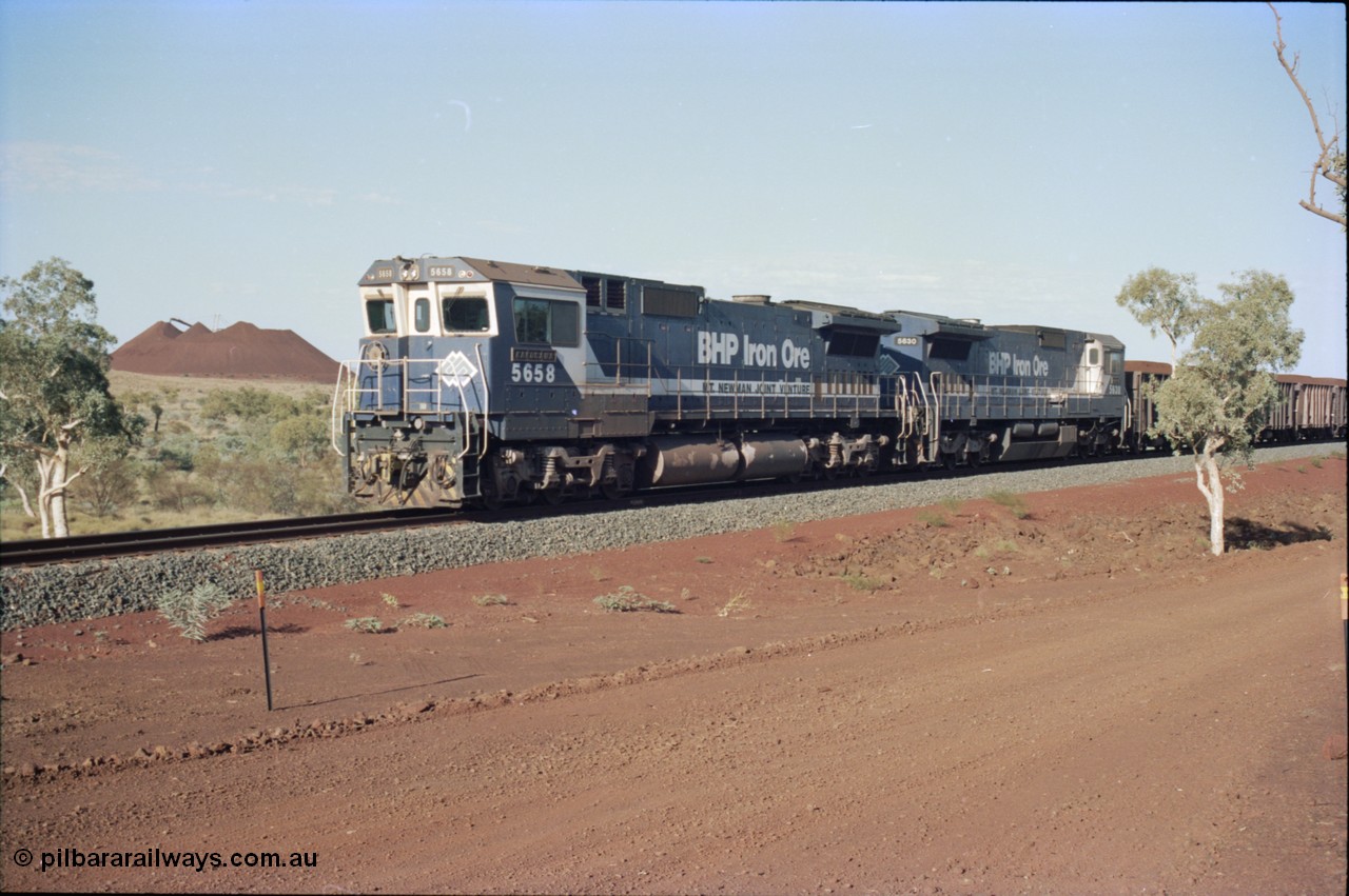 234-25
Yandi Two, BHP Iron Ore Goninan rebuild CM40-8M GE unit 5658 'Kakogawa' serial 8412-03 / 94-149 on the front of a 240 waggon loaded train, this configuration was trialled for a time with two Dash 8 locos, 120 waggons, Dash 8, 120 waggons and Dash 8. View looking from 5658 back to the ore stockpile at the loadout. Circa 1998.
Keywords: 5658;Goninan;GE;CM40-8M;8412-03/94-149;rebuild;AE-Goodwin;ALCo;M636C;5480;G6061-1;