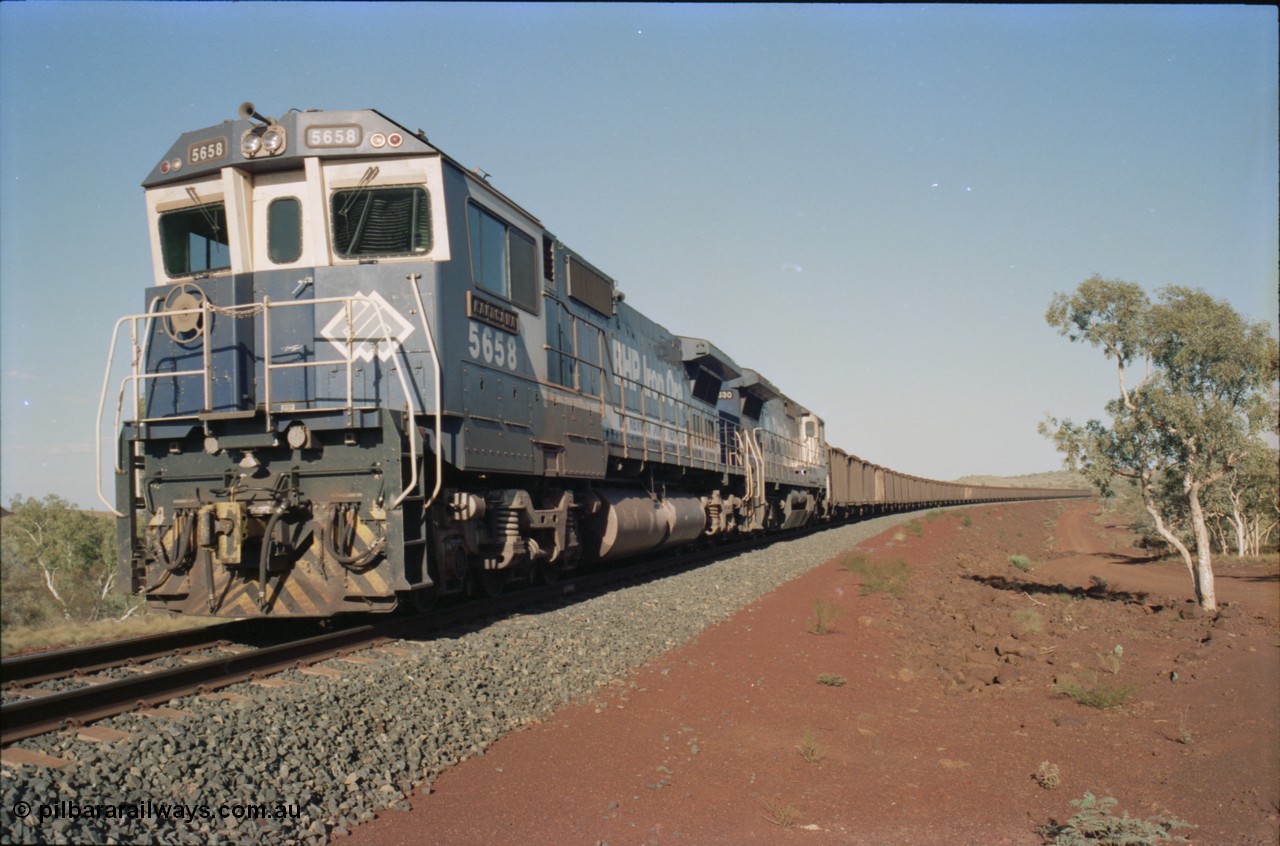 234-29
Yandi Two, BHP Iron Ore Goninan rebuild CM40-8M GE unit 5658 'Kakogawa' serial 8412-03 / 94-149 on the front of a 240 waggon loaded train, this configuration was trialled for a time with two Dash 8 locos, 120 waggons, Dash 8, 120 waggons and Dash 8. Cab front on view. Circa 1998.
Keywords: 5658;Goninan;GE;CM40-8M;8412-03/94-149;rebuild;AE-Goodwin;ALCo;M636C;5480;G6061-1;