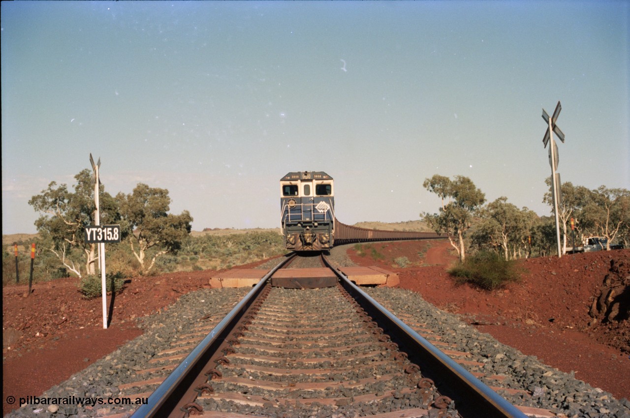 234-36
Yandi Two, BHP Iron Ore Goninan rebuild CM40-8M GE unit 5658 'Kakogawa' serial 8412-03 / 94-149 on the front of a 240 waggon loaded train, this configuration was trialled for a time with two Dash 8 locos, 120 waggons, Dash 8, 120 waggons and Dash 8. View looking across the YT315.8 km grade crossing and 5658 back to the ore stockpile at the loadout. Circa 1998.
Keywords: 5658;Goninan;GE;CM40-8M;8412-03/94-149;rebuild;AE-Goodwin;ALCo;M636C;5480;G6061-1;