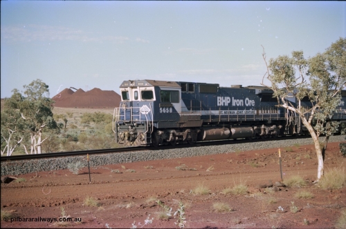 234-31
Yandi Two, BHP Iron Ore Goninan rebuild CM40-8M GE unit 5658 'Kakogawa' serial 8412-03 / 94-149 on the front of a 240 waggon loaded train, this configuration was trialled for a time with two Dash 8 locos, 120 waggons, Dash 8, 120 waggons and Dash 8. View looking from 5658 back to the ore stockpile at the loadout. Circa 1998.
Keywords: 5658;Goninan;GE;CM40-8M;8412-03/94-149;rebuild;AE-Goodwin;ALCo;M636C;5480;G6061-1;