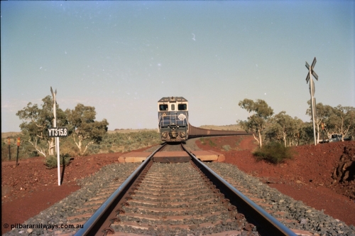 234-36
Yandi Two, BHP Iron Ore Goninan rebuild CM40-8M GE unit 5658 'Kakogawa' serial 8412-03 / 94-149 on the front of a 240 waggon loaded train, this configuration was trialled for a time with two Dash 8 locos, 120 waggons, Dash 8, 120 waggons and Dash 8. View looking across the YT315.8 km grade crossing and 5658 back to the ore stockpile at the loadout. Circa 1998.
Keywords: 5658;Goninan;GE;CM40-8M;8412-03/94-149;rebuild;AE-Goodwin;ALCo;M636C;5480;G6061-1;