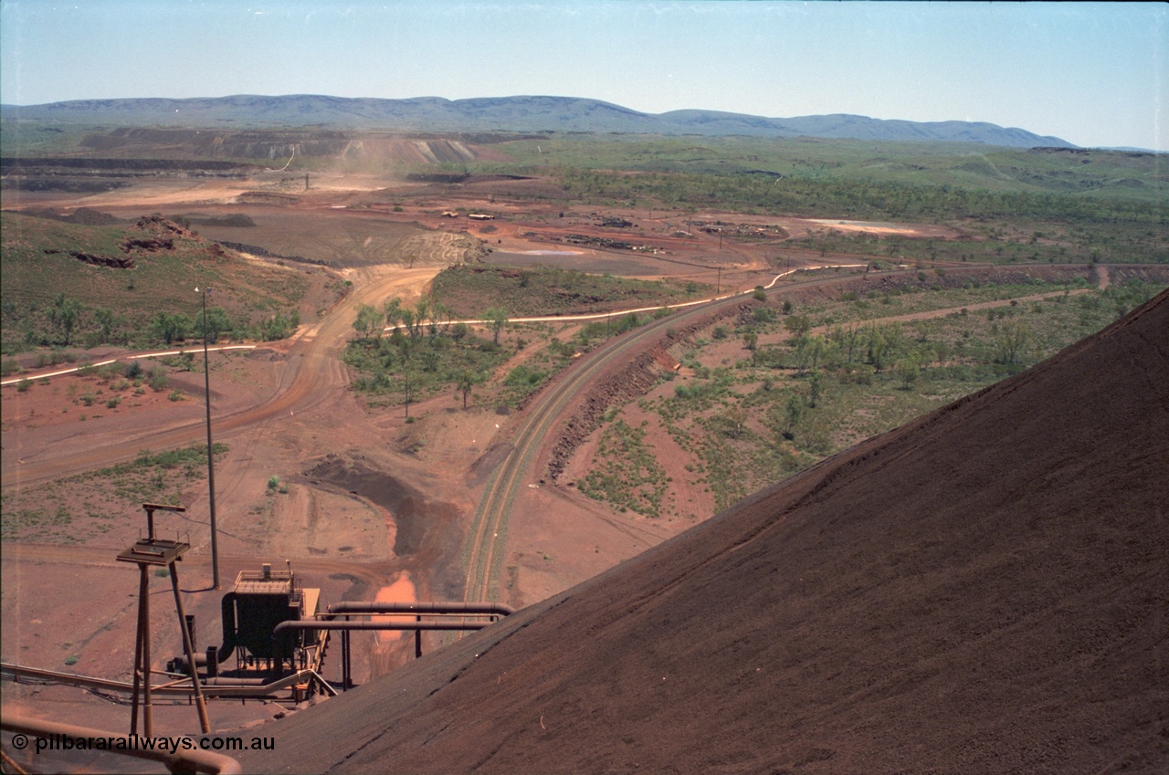 239-05
View from the radial stacker boom at Yandi One looking west, the rail loading balloon loop and dust extractor are visible at the bottom of the image and the mine waste dump is in the background. [url=https://goo.gl/maps/hApNXoLtbtQ2]GeoData[/url].

