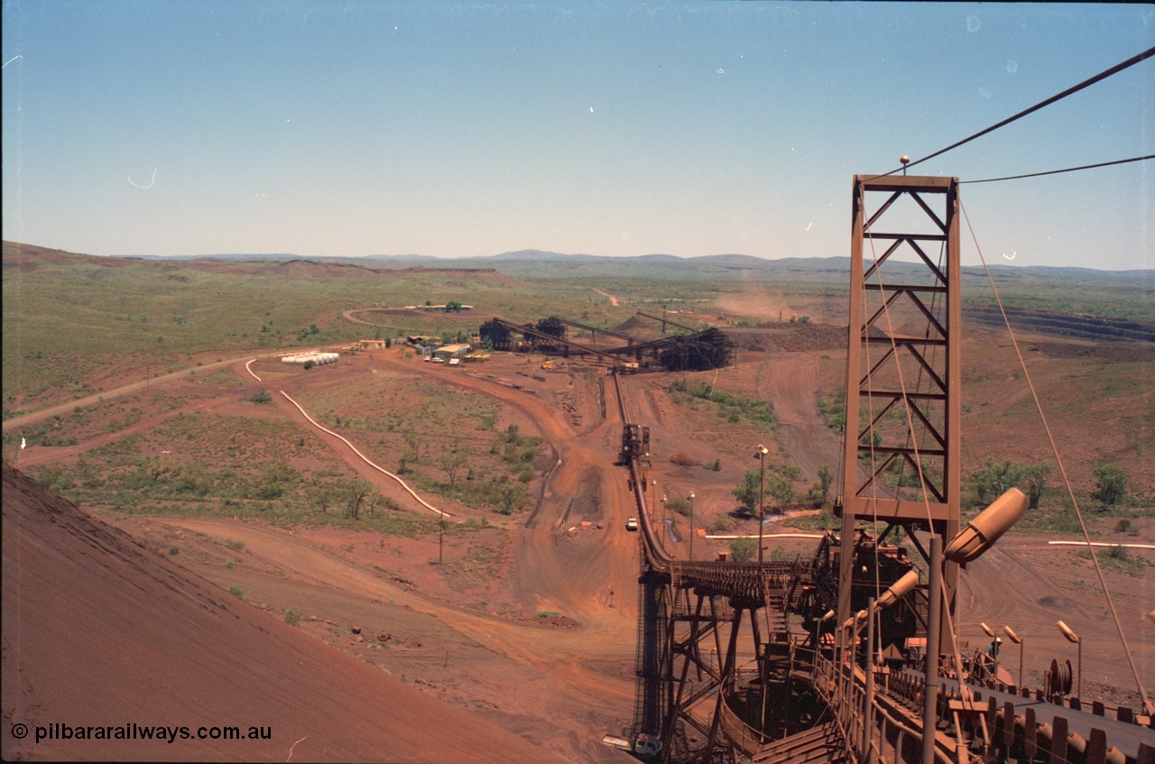 239-09
Overview of Yandi One mine from the end of the radial stacker boom looking south. Buildings visible from the left, diesel fuel farm, sample hut, workshops beyond the power station and the offices in the background. [url=https://goo.gl/maps/hApNXoLtbtQ2]GeoData[/url].
