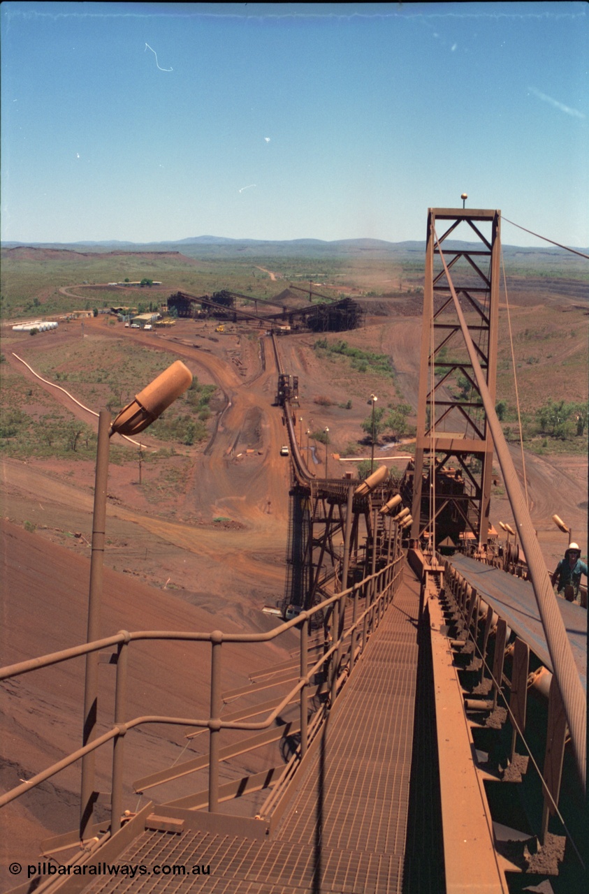 239-10
Overview of Yandi One mine from the end of the radial stacker boom, CV21, looking south along CV20 towards the OHP. Buildings visible from the left, diesel fuel farm, sample hut, workshops beyond the power station and the offices in the background. [url=https://goo.gl/maps/hApNXoLtbtQ2]GeoData[/url].

