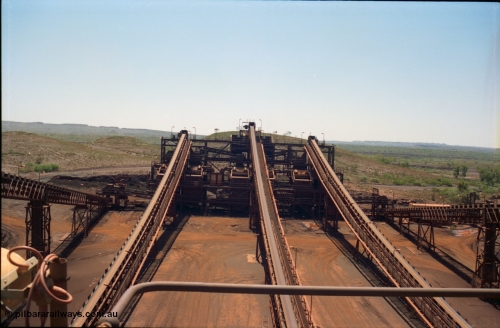 239-13
Overview of the Yandi One sizing plant looking north from above the middling crushers along CV4 (middle belt) to the screen house which houses six Jaques 'banana screens'. The feed bin and associated feed conveyors, travelling left and right can be clearly seen. The 'new side' is on the left and the 'old side' on the right. The feed along CV10 to the stockpile is obscured by the 'old side' structure and Sub-Station 3 can just be made out. [url=https://goo.gl/maps/2oJ3zTdoX1p]GeoData[/url].
