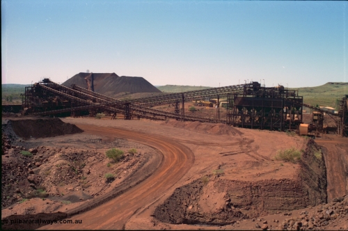 239-22
Overview of Yandi One OHP plant as viewed from the head end of CV2 conveyor which runs from the primary crusher to the reclaim pile. Visible from the left is the screen house, radial stacker on the stockpile, power station, new and old side tertiary crushing structures, sub-station 4, the control room and on the extreme right the secondary crusher structure. [url=https://goo.gl/maps/EyA7dYyg3yK2]GeoData[/url].
