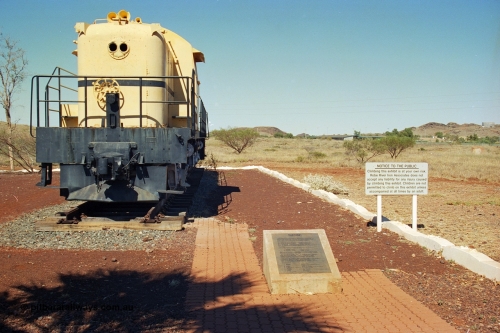 240-25
Wickham town entry statement, former Cliffs Robe River Iron Associates RSC-3 model ALCo locomotive built by Montreal Locomotive Works (MLW) in 1951 for NSWGR as the 40 class 4006 serial 77737, purchased by CRRIA in 1971 and numbered 261.001, then 1700 and finally 9401. It has been repainted into Robe colours and was donated to the local Lions' Club when retired and displayed as an entry statement to the township. View on the rail plinth and plaque at the entry into town. 31st August 2002.
Keywords: 9401;MLW;ALCo;RSC3;77737;40-class;4006;