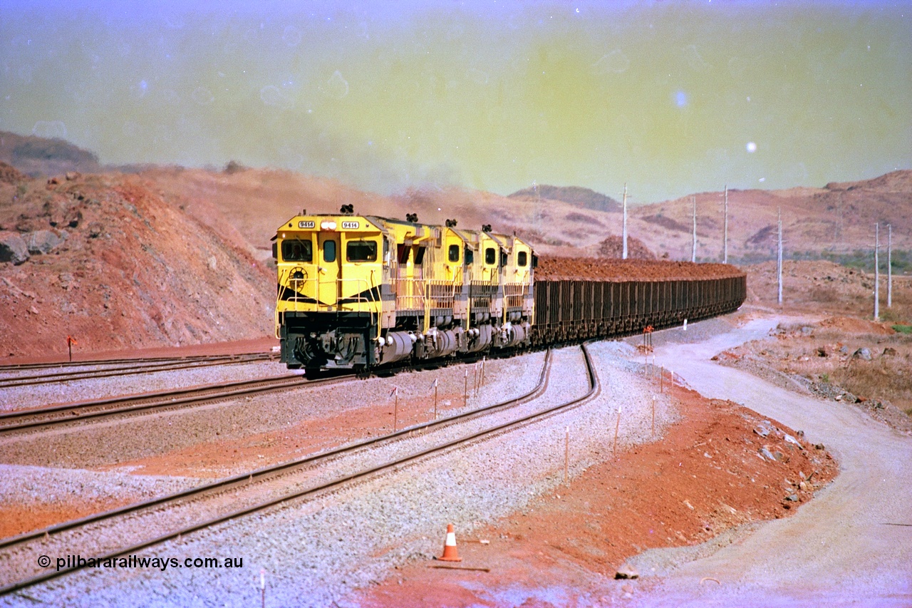 246-15
Cape Lambert, yard view of the then new extension to the south for the West Angelas mine was coming on stream as a Robe River loaded Deepdale train arrives on the main behind the standard quad Dash 8 power with 202 waggons. 9414 which is a Goninan WA ALCo to GE rebuild CM40-8M with serial 8206-11 / 91-124 from November 1991 and was originally an AE Goodwin built M636 ALCo built new for Robe in December 1971 and numbered 262.005, later numbered 1714. 22nd May 2002.
Keywords: 9414;Goninan;GE;CM40-8M;8206-11/91-124;rebuild;AE-Goodwin;ALCo;M636;G6060-5;