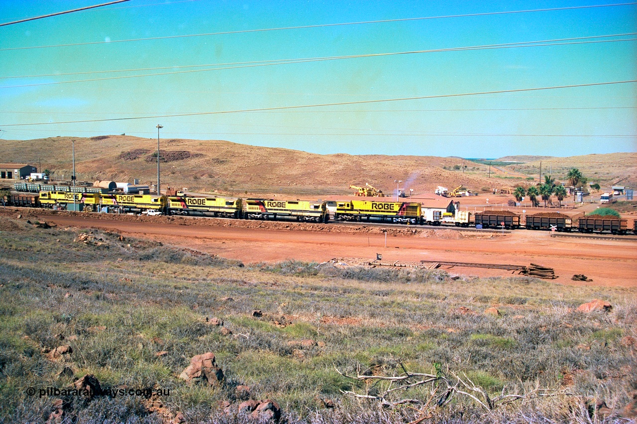 247-21
Cape Lambert yard view with Robe River Comeng WA ALCo Schenectady NY model rebuild C636R unit 9426 dragging a loaded 101 waggon rake from the South Yard across Bells Crossing while a brace of four Goninan CM40-8M GE rebuilds wait at the fuel point for a departure with an empty train. Approximate location of photo is [url=https://goo.gl/maps/TvJoLDjReJ2xoob69]here[/url]. 22nd May 2002.
Keywords: 9426;Comeng-WA;C636R;WA143-1;rebuild;ALCo;Schenectady-NY;C636;Conrail;6782;3499-3;