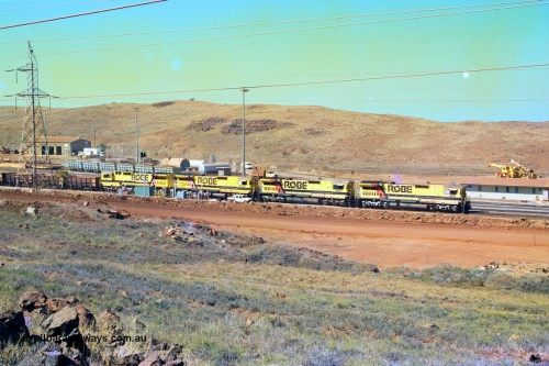 247-15
Cape Lambert overview of the fuel point, with a brace of four CM40-8M rebuilds finishing up refuelling before departing with another empty train. The workshops are to the left of the picture. Where I'm standing to take the picture is now all stockpile. Approximate location of photo is [url=https://goo.gl/maps/B9F4estGGPbd2GrB6]here[/url]. 22nd May 2002.
Keywords: 9425;Goninan;GE;CM40-8M;6266-8/89-85;rebuild;AE-Goodwin;ALCo;M636;G-6041-4;