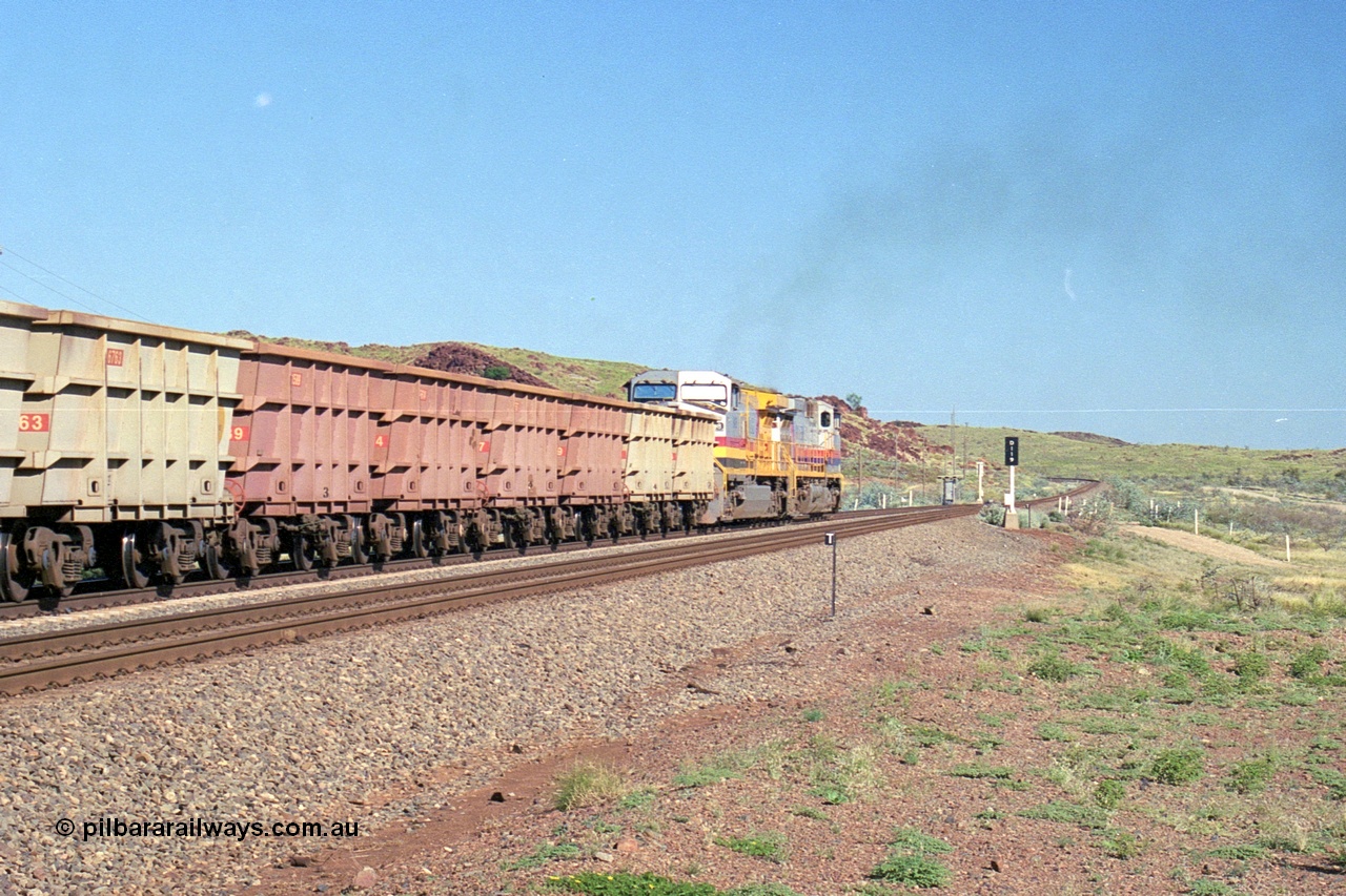 248-13
Dingo Siding on the Hamersley Iron railway at the 39 km with an empty train headed up by a pair of General Electric built Dash 9-44CW units 7077 serial 47756 from the original first order in the Pepsi Can livery and 9408 serial 54158 from the fourth order in the Pilbara Rail livery with Robe ownership markings powers away to the south with the signal marker boards are in the distance. Approximate [url=https://goo.gl/maps/Jv752bD5KXv28oUV7]location[/url]. 24th April 2004.
