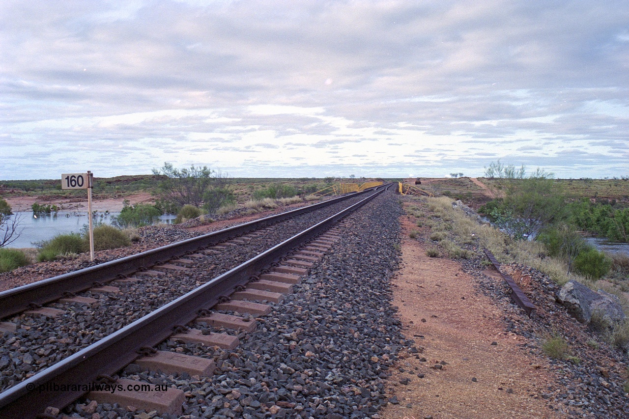 249-13
Yule River bridge looking north from the 160 km on the BHP mainline. The third pier from the southern end was undermined by flood waters from Tropical Cyclone John in December 1999. The rail line was closed for two weeks while repairs were effected. Approximate [url=https://goo.gl/maps/phCWr8u1xnuBdzwj6]location[/url].
