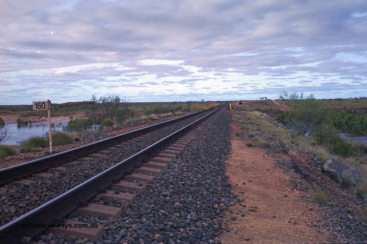 249-14
Yule River bridge looking north from the 160 km on the BHP mainline. The third pier from the southern end was undermined by flood waters from Tropical Cyclone John in December 1999. The rail line was closed for two weeks while repairs were effected. Approximate [url=https://goo.gl/maps/phCWr8u1xnuBdzwj6]location[/url].
