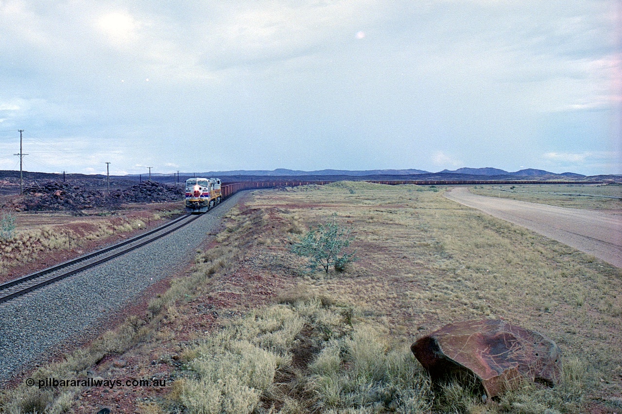 249-29
A loaded Hamersley Iron train runs across the plains north of Dingo Siding near the 70 km as it nears the destination of its cargo behind the standard pair of GE built Dash 9-44CW locomotives 7084 serial 47763 and 7079 serial 47758 both in the original Pepsi Can livery. Approximate [url=https://goo.gl/maps/UUfj15vTkvBaPCaw8]location[/url]. 18th December 1999.
Keywords: 7084;GE;Dash-9-44CW;47763;
