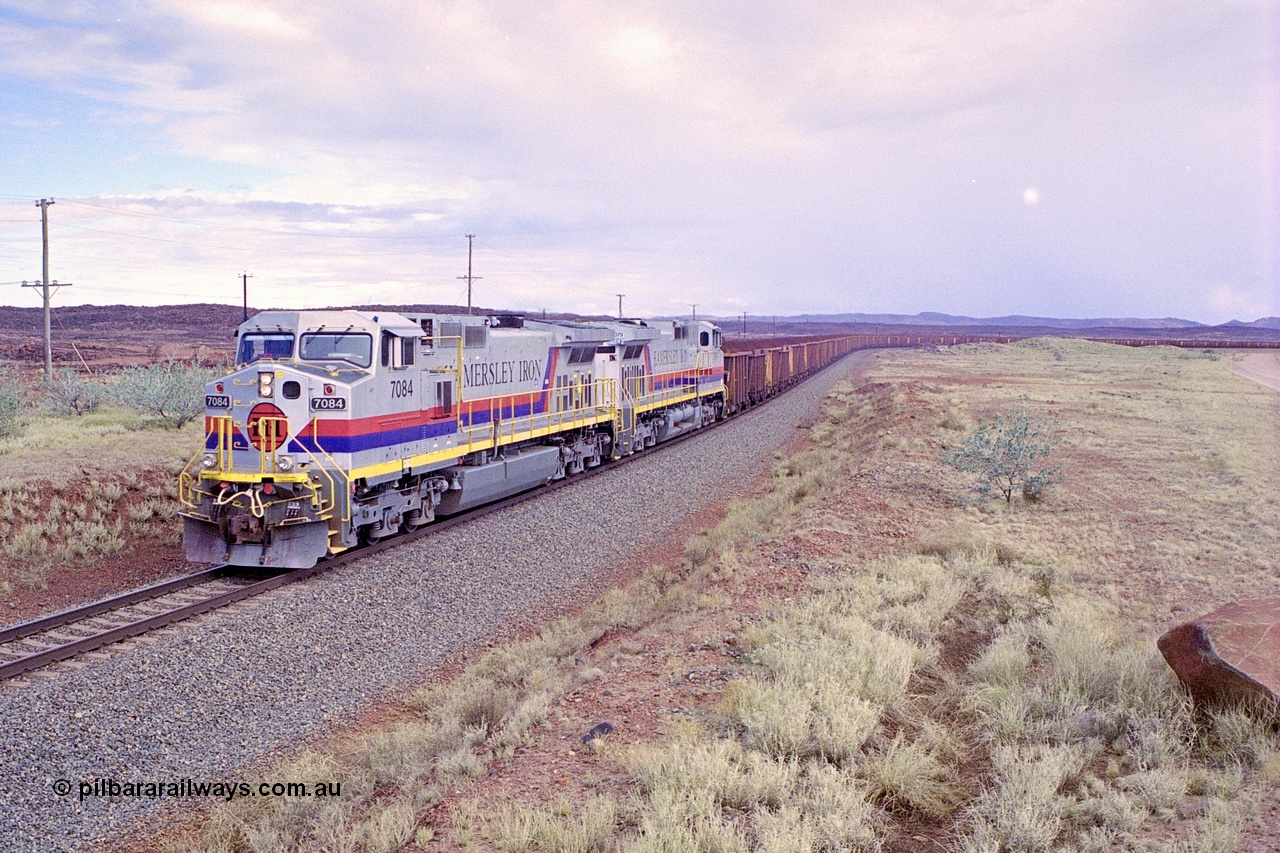 249-31
A loaded Hamersley Iron train runs across the plains north of Dingo Siding near the 70 km as it nears the destination of its cargo behind the standard pair of GE built Dash 9-44CW locomotives 7084 serial 47763 and 7079 serial 47758 both in the original Pepsi Can livery. Approximate [url=https://goo.gl/maps/UUfj15vTkvBaPCaw8]location[/url]. 18th December 1999.
Keywords: 7084;GE;Dash-9-44CW;47763;