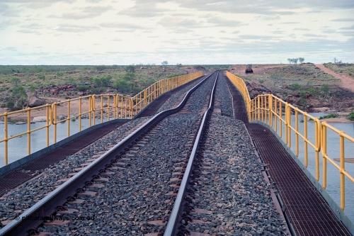 249-05
Yule River bridge looking north from the 160 km on the BHP mainline. The third pier from the southern end was undermined by flood waters from Tropical Cyclone John in December 1999. The rail line was closed for two weeks while repairs were effected. Approximate [url=https://goo.gl/maps/phCWr8u1xnuBdzwj6]location[/url].
