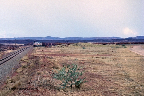 249-26
A loaded Hamersley Iron train runs across the plains north of Dugite Siding near the 70 km as it nears the destination of its cargo. Approximate [url=https://goo.gl/maps/UUfj15vTkvBaPCaw8]location[/url]. 18th December 1999.
