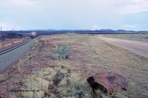 249-28
A loaded Hamersley Iron train runs across the plains north of Dugite Siding near the 70 km as it nears the destination of its cargo behind the standard pair of GE built Dash 9-44CW locomotives 7084 serial 47763 and 7079 serial 47758 both in the original Pepsi Can livery. Approximate [url=https://goo.gl/maps/UUfj15vTkvBaPCaw8]location[/url]. 18th December 1999.
Keywords: 7084;GE;Dash-9-44CW;47763;