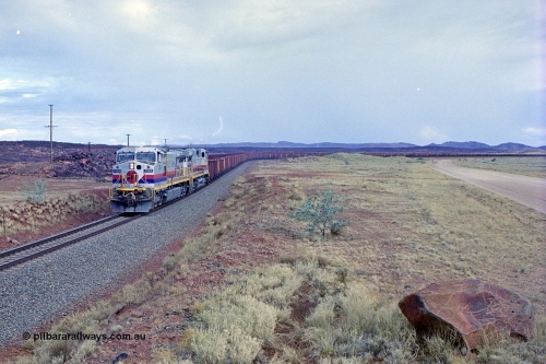 249-30
A loaded Hamersley Iron train runs across the plains north of Dugite Siding near the 70 km as it nears the destination of its cargo behind the standard pair of GE built Dash 9-44CW locomotives 7084 serial 47763 and 7079 serial 47758 both in the original Pepsi Can livery. Approximate [url=https://goo.gl/maps/UUfj15vTkvBaPCaw8]location[/url]. 18th December 1999.
Keywords: 7084;GE;Dash-9-44CW;47763;