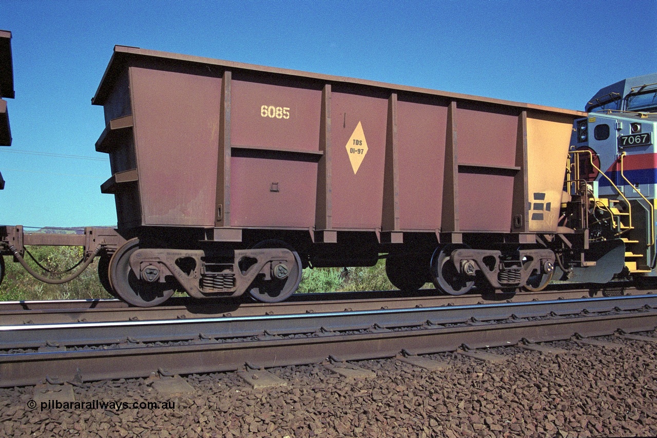 250-07
Pelican Siding on the Hamersley Iron Tom Price line about the 208 km empty ore waggon 6085 is an example of the units built by Tomlinson Steel WA is a slave waggon of the pair and shows the re-sheeting paint symbol to indicate that all four sides and the floor have been replaced. 21st October 2000.
Keywords: 6085;Tomlinson-Steel;M-series;