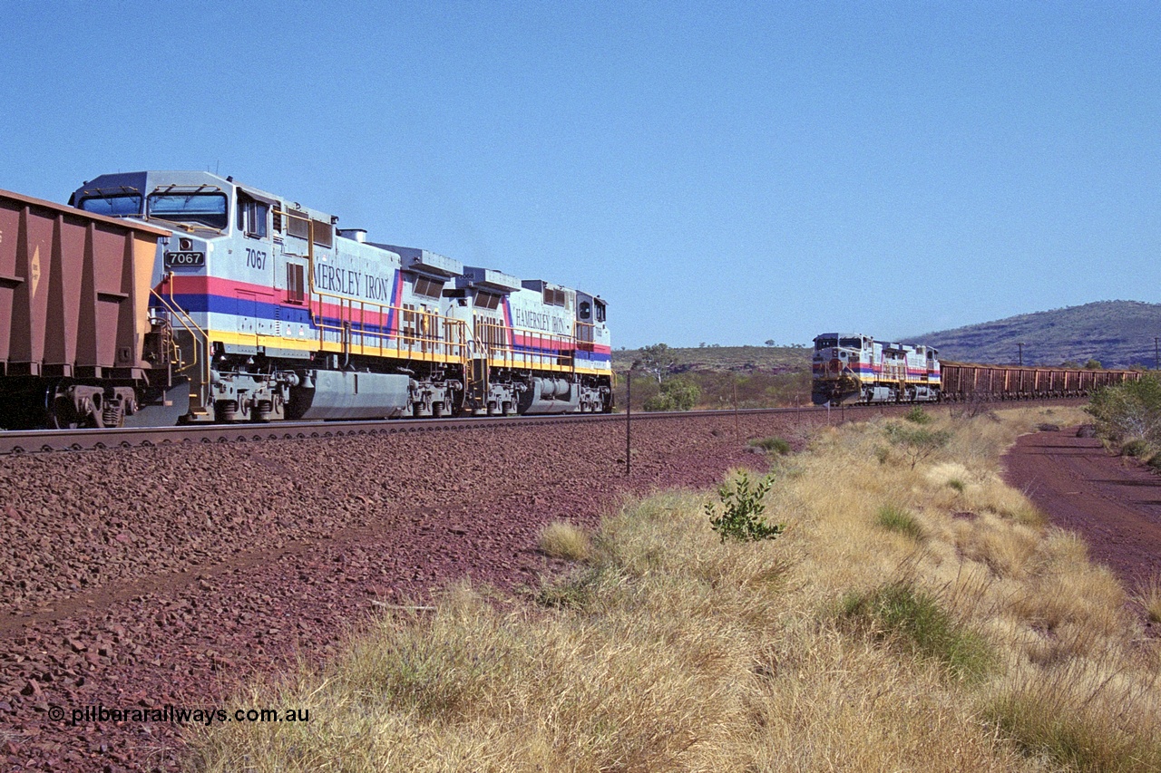 250-10
Pelican Siding on the Hamersley Iron Tom Price line about the 208 km with an empty train behind General Electric built 9-44CW units 7068 serial 47747 and 7067 serial 47746 on the loop as a loaded train with 210 waggons passes behind a sister pairing of 7072 serial 47751 and 7074 serial 47753. 1550 hrs 21st October 2000.
Keywords: 7067;GE;Dash-9-44CW;47746;