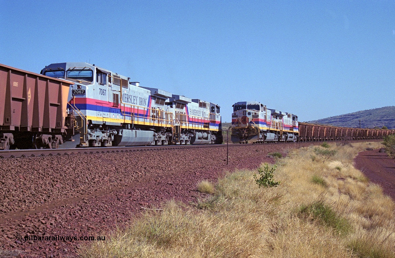 250-11
Pelican Siding on the Hamersley Iron Tom Price line about the 208 km with an empty train behind General Electric built 9-44CW units 7068 serial 47747 and 7067 serial 47746 on the loop as a loaded train with 210 waggons passes behind a sister pairing of 7072 serial 47751 and 7074 serial 47753. 1550 hrs 21st October 2000.
Keywords: 7072;GE;Dash-9-44CW;47751;